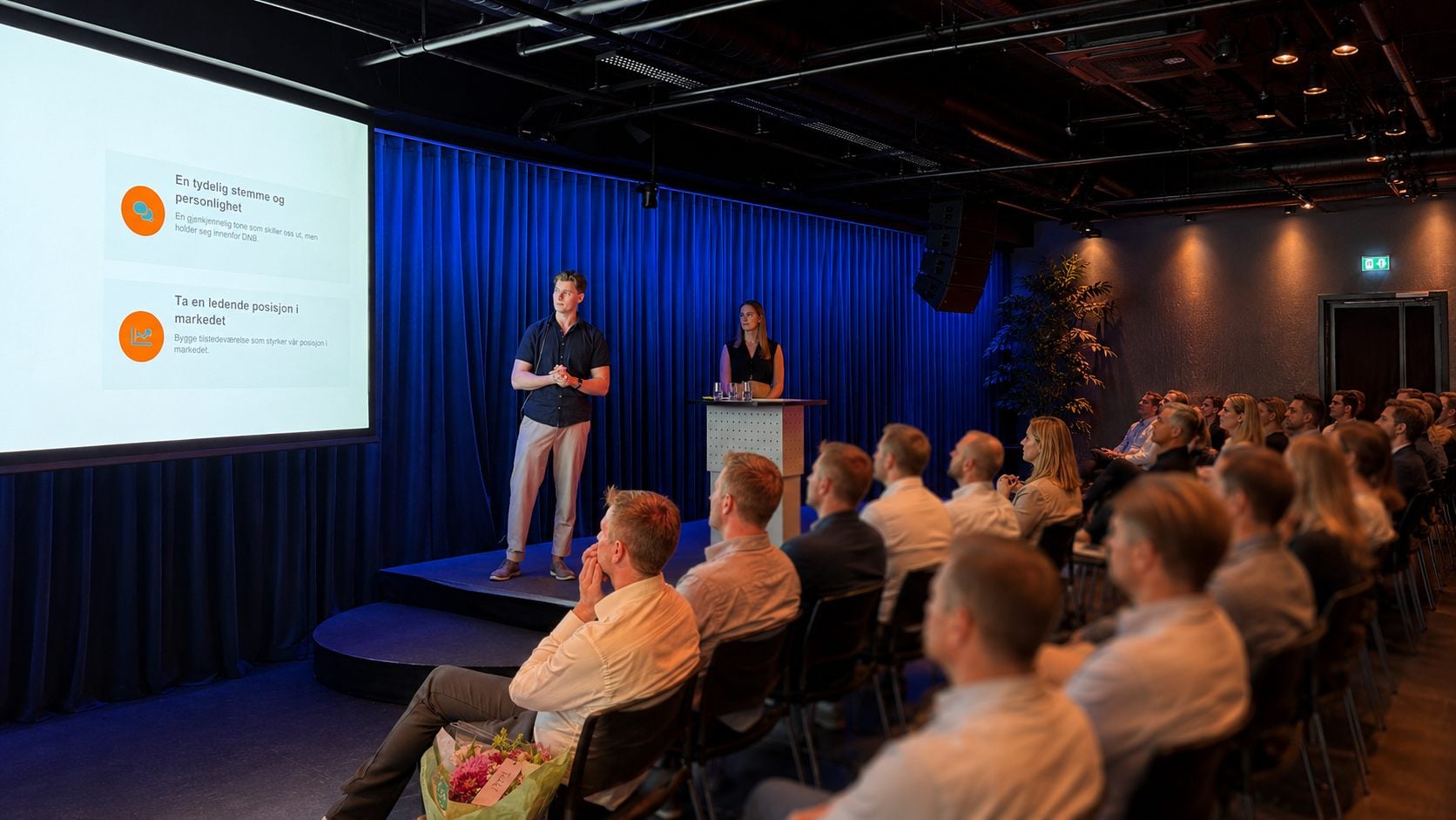 Presentasjon på scene foran et engasjert publikum